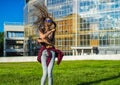 Carefree girl with zizi cornrows dreadlocks dancing on green lawn Royalty Free Stock Photo