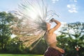 Carefree girl with zizi cornrows dreadlocks dancing on green lawn