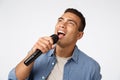 Carefree good-looking young man having fun during christmas party, singing favorite song, hold microphone bending as
