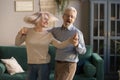 Carefree happy active old couple dancing laughing in living room Royalty Free Stock Photo