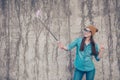Carefree and happy, funky mood. Cute young hipster is making selfie outdoors on a camera of her phone with selfie stick. She is w Royalty Free Stock Photo