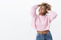 Carefree happy and outgoing delighted bright african american young girl with blond curly haircut tilting head joyfully