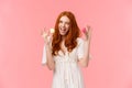 Carefree, happy outgoing redhead female in white dress, invite friends have bite, try delicious desserts, holding two Royalty Free Stock Photo