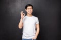 Carefree happy smiling young asian guy left satisfied after trying new product, visit company and use their good Royalty Free Stock Photo