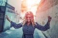 Carefree happy woman dancing on moody narrow street in sunset Royalty Free Stock Photo