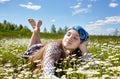 Carefree happy woman lying on green grass meadow and enjoying sun on her face. Girl resting in spring park Royalty Free Stock Photo