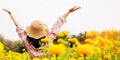 Carefree happy woman travelling in a beautiful yellow flower garden arms up enjoying fresh nature Royalty Free Stock Photo