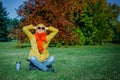 Carefree hipster woman with raised hands sitting on green lawn enjoying good weather. Outdoor coffee break. Happy lifestyle Royalty Free Stock Photo