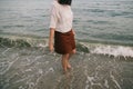 Carefree hipster woman walking barefoot in sea waves on beach. Feet in water foam. Mindfulness Royalty Free Stock Photo