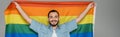 Carefree homosexual man holding lgbt flag