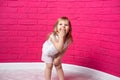 Carefree joyful little girl laughing out loud giggling covering her mouth with her hand on pink background Royalty Free Stock Photo