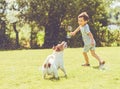 Carefree kid and pet dog playing with flying soap bubbles at sunny summer day Royalty Free Stock Photo