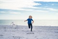 Carefree kid running, chasing birds. Child run on the seagulls on the beach, summer time. Cute little boy chasing birds