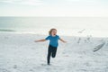 Carefree kid running, chasing birds. Little kid boy having fun on Miami beach. Happy cute child running near ocean Royalty Free Stock Photo