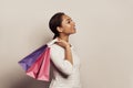Carefree lady posing after shopping. Cute black female model enjoying sales and holding shopping bags