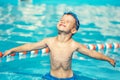 Carefree little caucasian boy spread arms in pool