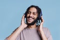 Carefree man listening to songs playlist in wireless headphones
