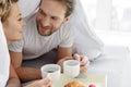 Carefree man and woman enjoying coffee in bedroom Royalty Free Stock Photo