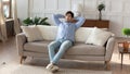 Carefree millennial man resting on sofa taking break from work Royalty Free Stock Photo