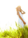 Carefree moments. A beautiful young blonde woman standing in a meadow wearing a sunhat on a warm summers day. Royalty Free Stock Photo