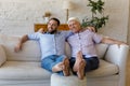 Carefree older man his son relax on sofa at home