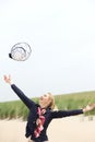 Carefree older woman throwing hat up with outstretched arms Royalty Free Stock Photo