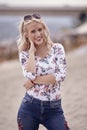 Carefree portrait, one young woman, 25 years old, floral pattern top, jeans. looking down, smiling joy. Royalty Free Stock Photo