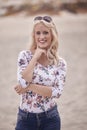 Carefree portrait, one young woman, 25 years old, floral pattern top, jeans. looking down, smiling joy. Royalty Free Stock Photo