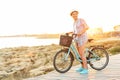Carefree pretty woman with bicycle riding on a wooden path at th
