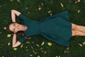 Carefree pretty woman lies on a green grass