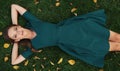 Carefree pretty woman is lying on green grass