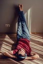 Carefree relaxed man wear jeans, wine red t-shirt listening to music lying down on parquet floor, feet on wall. Natural light and Royalty Free Stock Photo