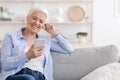 Carefree Retirement. Senior Woman Listening Music On Smartphone With Earphones At Home Royalty Free Stock Photo