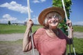 Carefree senior woman in straw hat swinging on a wooden swing, age beauty, baby boomer generation Royalty Free Stock Photo