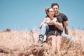 Carefree, smiling and relaxed couple bonding, having fun and looking at the view while sitting on the grass in a nature Royalty Free Stock Photo