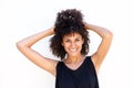 Carefree smiling woman standing with hands in curly hair