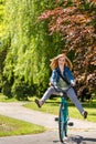 Carefree teenager riding bicycle across the park