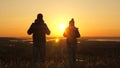 Carefree tourists travel at sunset. Teamwork in business. Free travelers, man and woman with backpacks, descend from Royalty Free Stock Photo