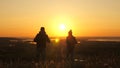 Carefree tourists travel at sunset. Teamwork in business. Free travelers, man and woman with backpacks, descend from Royalty Free Stock Photo