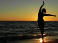 Carefree woman dancing in the sunset on the beach. Royalty Free Stock Photo