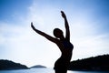 Carefree woman dancing in the sunset on the beach. Vacation vitality healthy living concept