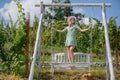 Carefree woman enjoy summer. Fashion girl on wooden bench. Woman relaxing outdoors on porch swing in the nature. Summer Royalty Free Stock Photo