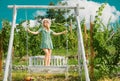 Carefree woman enjoy summer. Gorgeous girl is swinging on a swing and enjoying the beautiful summer weather at nature Royalty Free Stock Photo