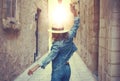 Carefree woman in hat dancing at old narrow street Royalty Free Stock Photo