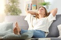 Carefree woman relaxing sitting on a sofa at home