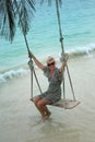 Carefree woman relaxing on tropical swing Royalty Free Stock Photo