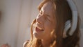 Carefree woman singing song in headphones closeup. Energetic girl in sunlight