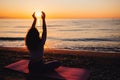 Carefree woman yoga practicing by the sea sunrise time