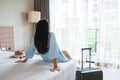 Carefree young Asian traveler woman relax on bed in hotel room. Travel alone, summer weekend, holiday concept. Royalty Free Stock Photo