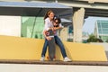 Carefree young couple has fun: girlfriend piggybacking boyfriend. Lovers girl and guy skateboarders